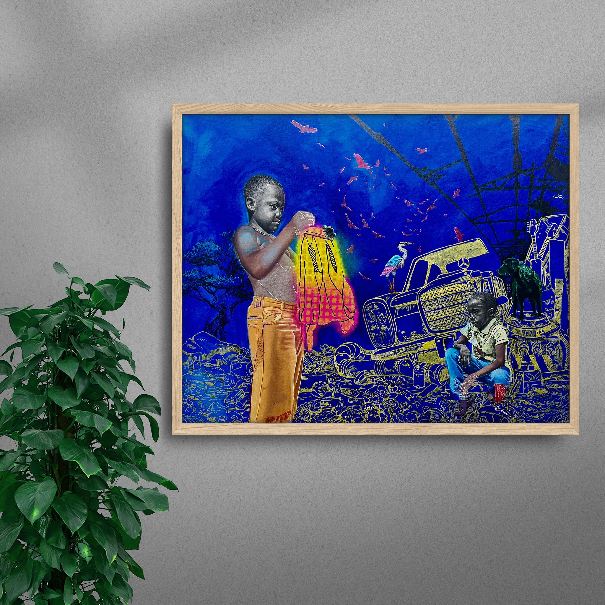 Framed Gold Mine black art print by Tolu Raymond, a contemporary African artwork featuring two young African boys in a surreal junkyard scene with a deep blue background, golden yellow mechanical elements, and a glowing red and yellow cloth, in a natural wood frame